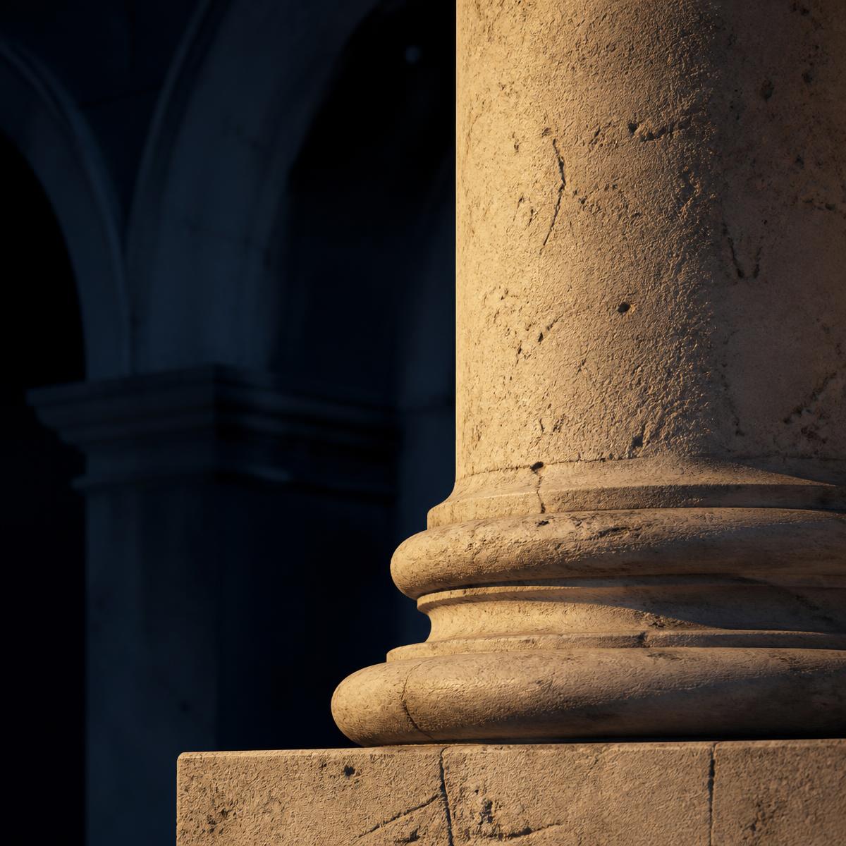 Detail of a classical stone column lit in warm gold light